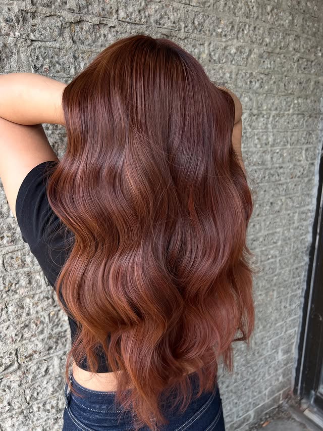 Rich copper waves against brick wall